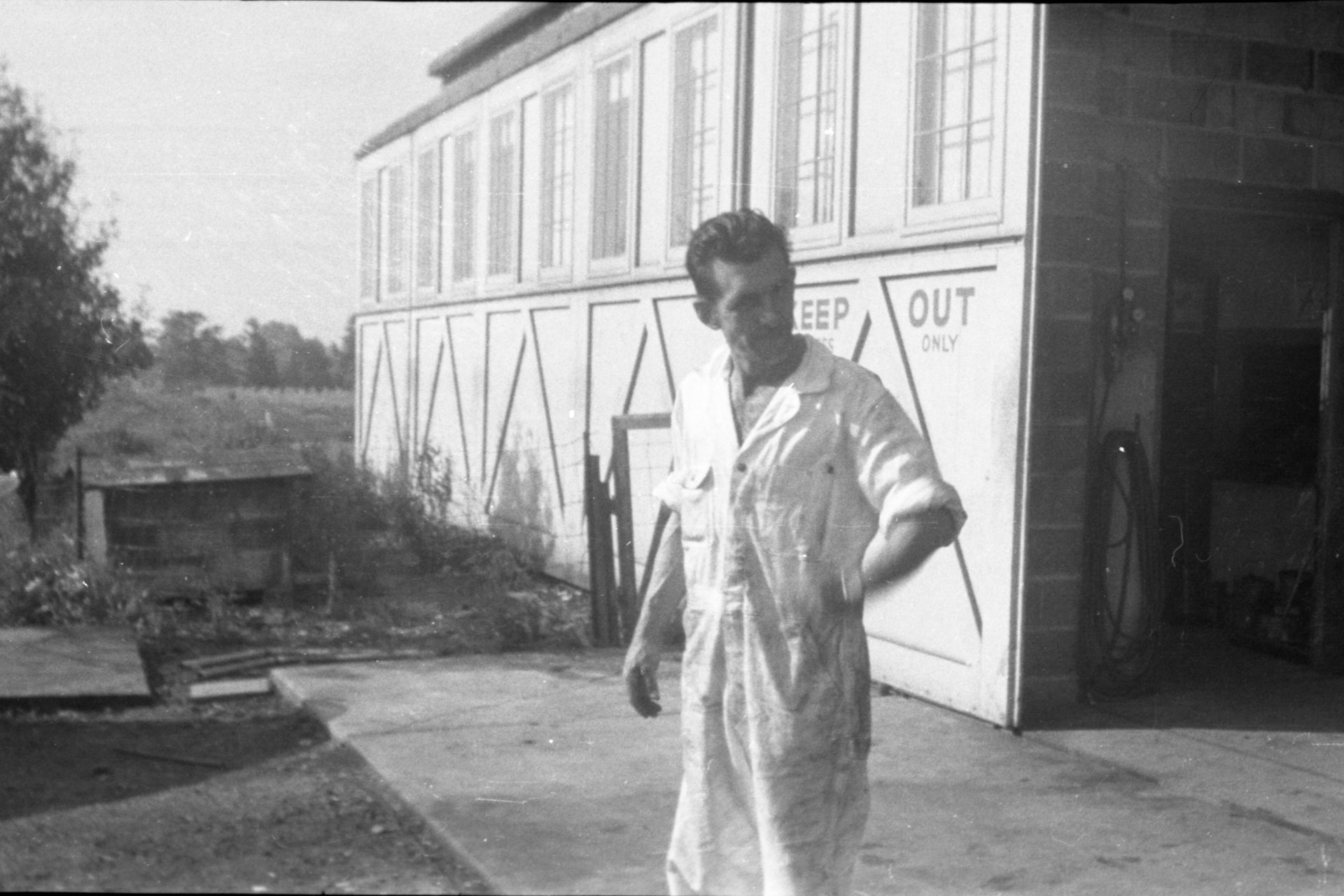 An unknown person standing outside of the Maintenance shop at Buffalo Airpark.
