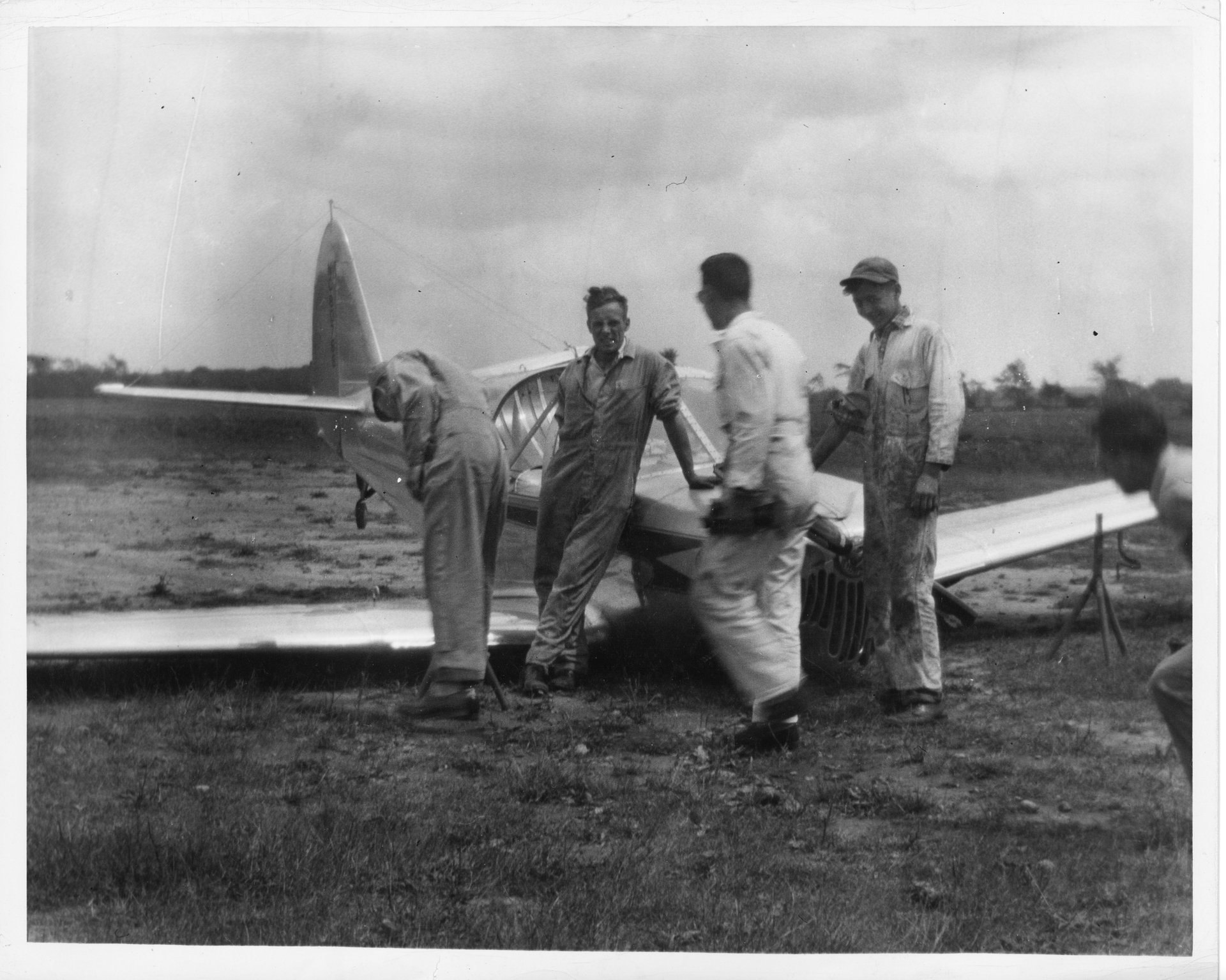 Tony Riccio and four unknown people inspect a damaged Globe Swift airplane sitting on it's wings in a field at Buffalo Airpark.