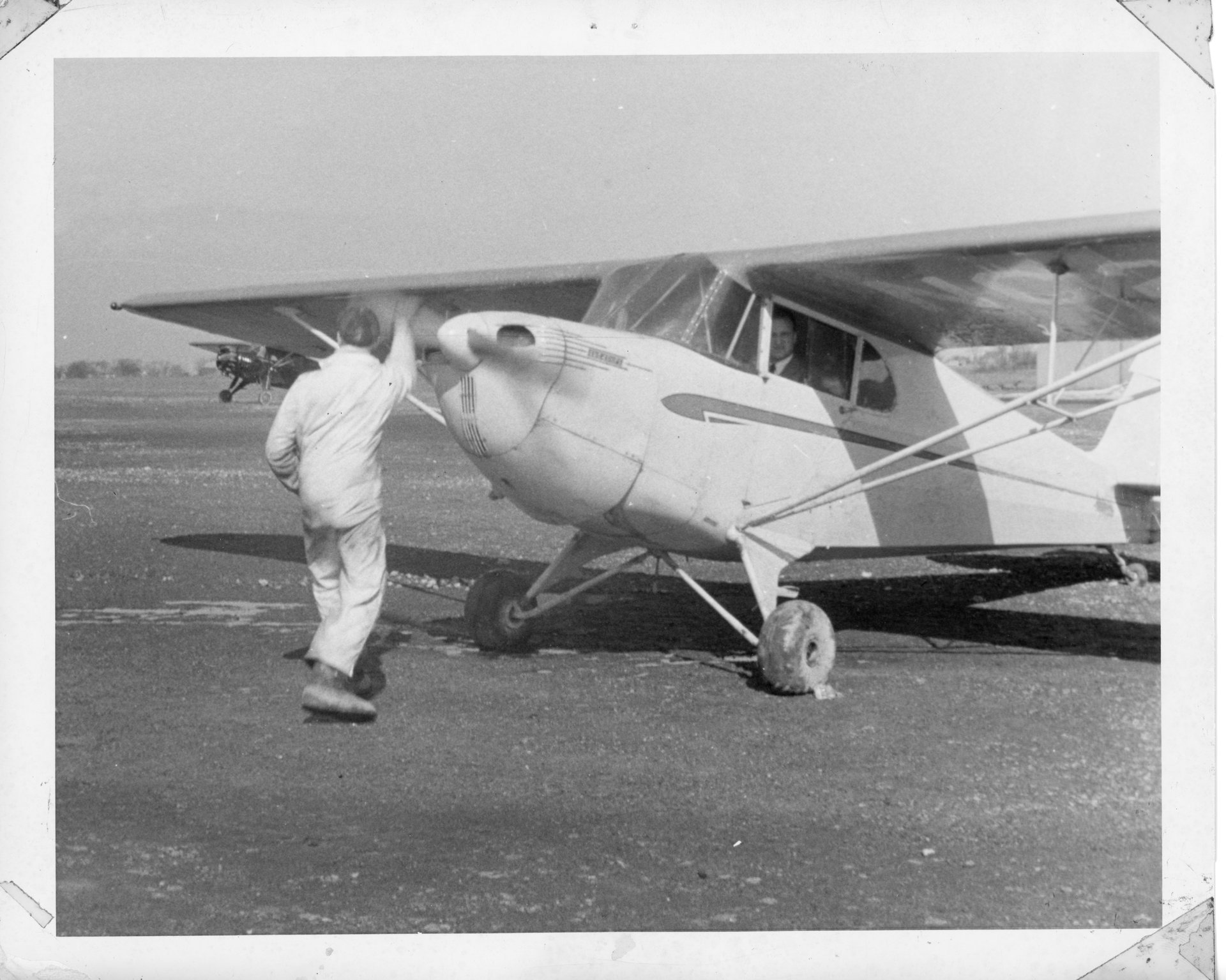 An unknown mechanic hand propping a Piper Cub at Buffalo Airpark.