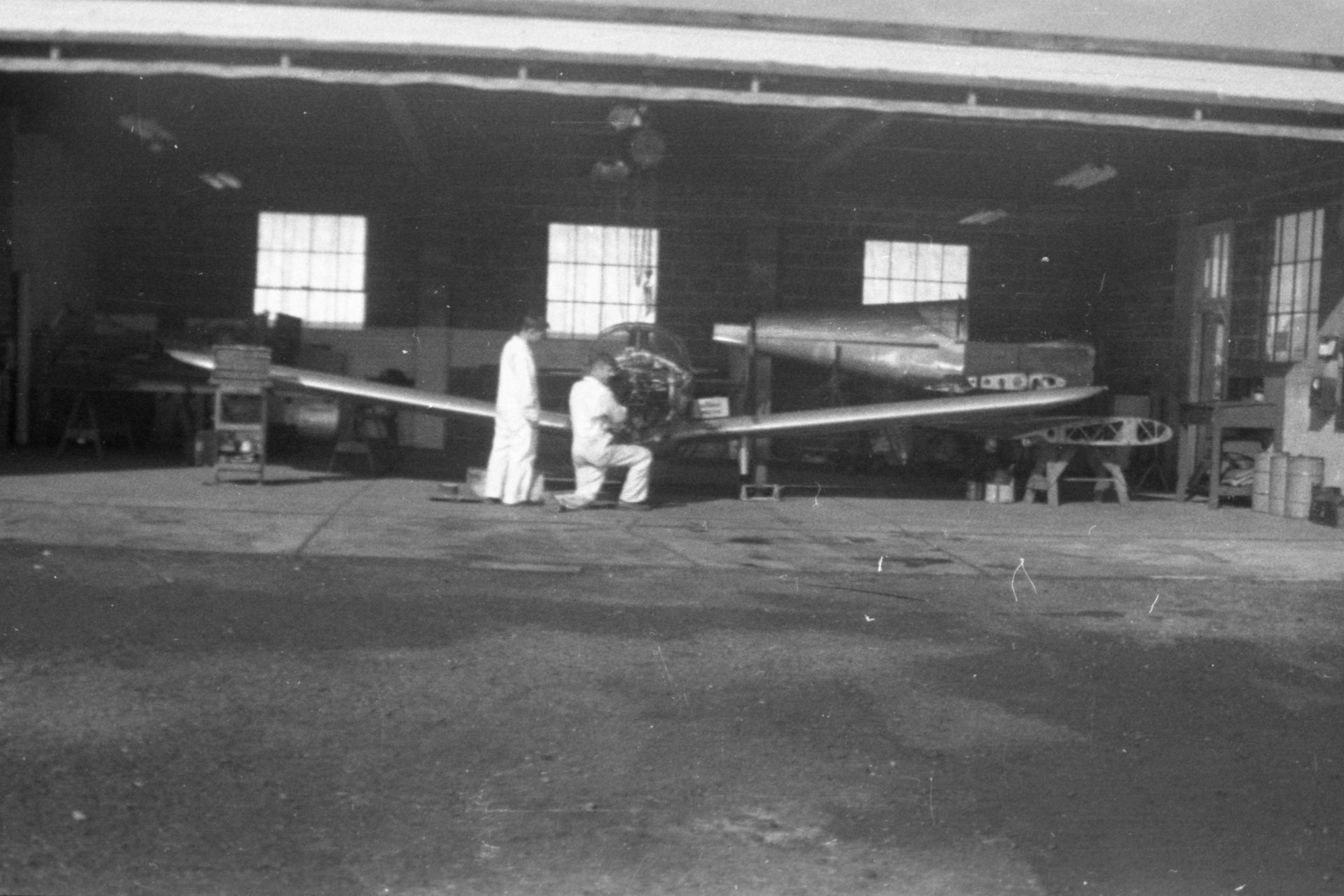 Two unknown mechanics working on a Globe Swift in the Maintenance shop at Buffalo Airpark.