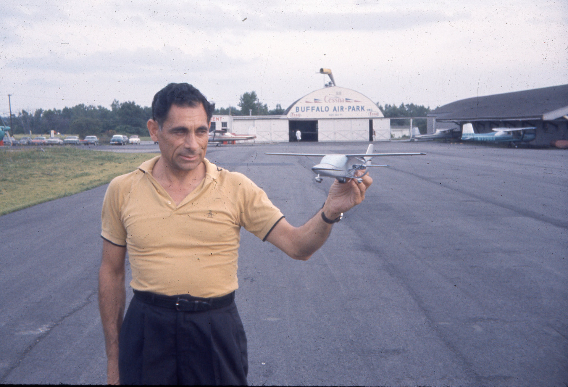 Tony Riccio at Buffalo Airpark standing on the tarmac while holding a model airplane.
