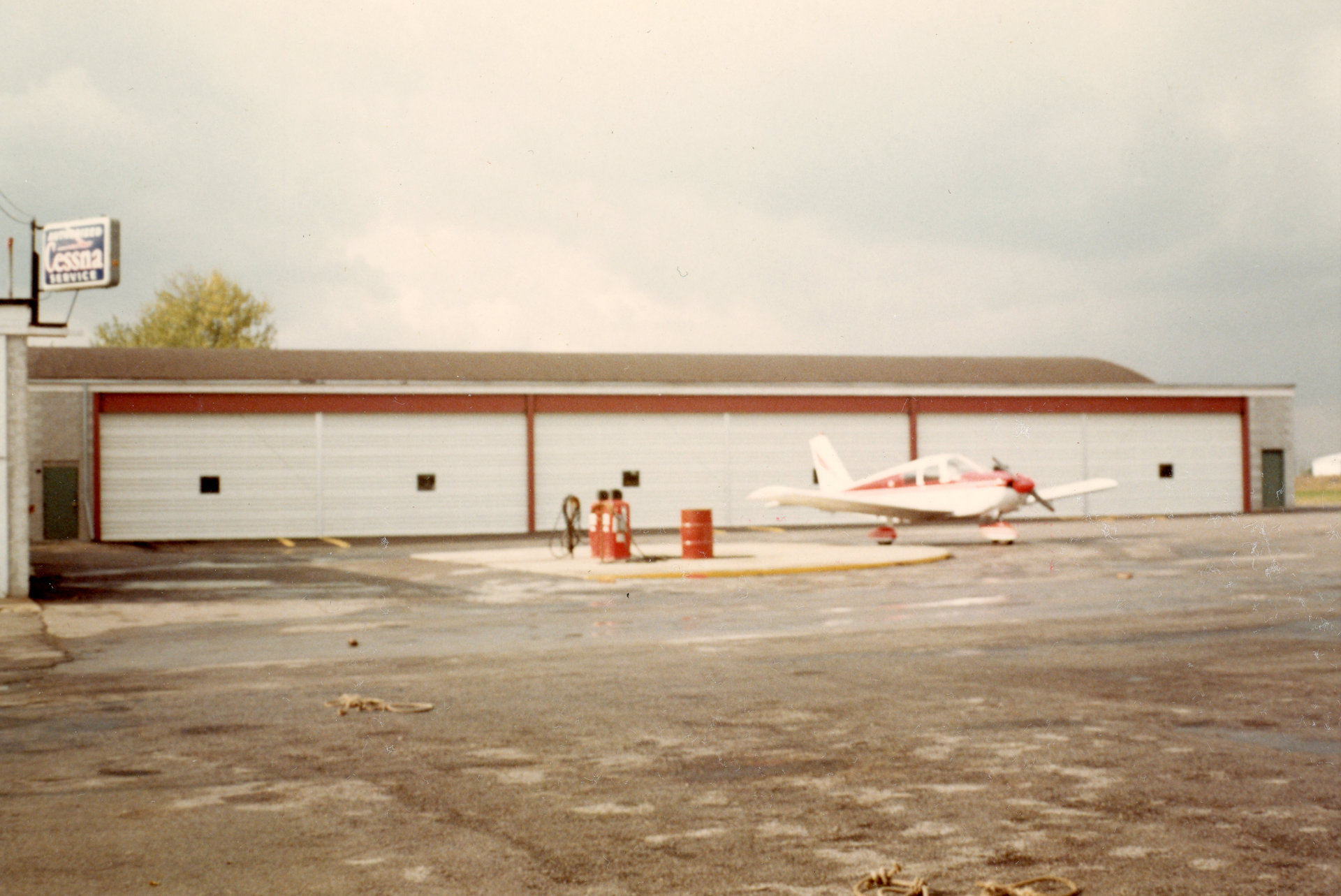 The fuel pump island at Buffalo Airpark with the three hangar bay additions in the background.