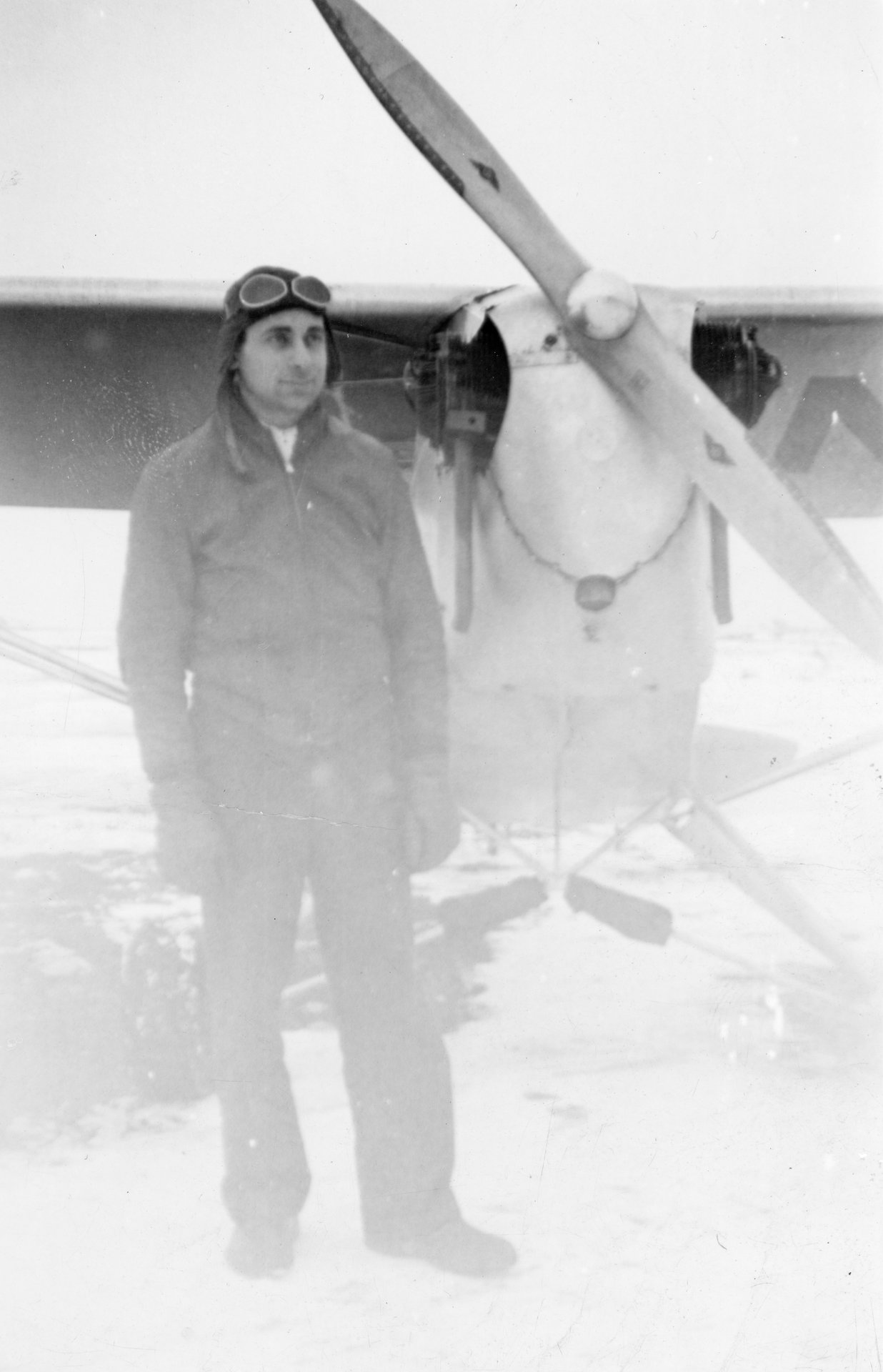 Tony Riccio standing on the right side of his J-3 "Cub" wearing his winter clothing.