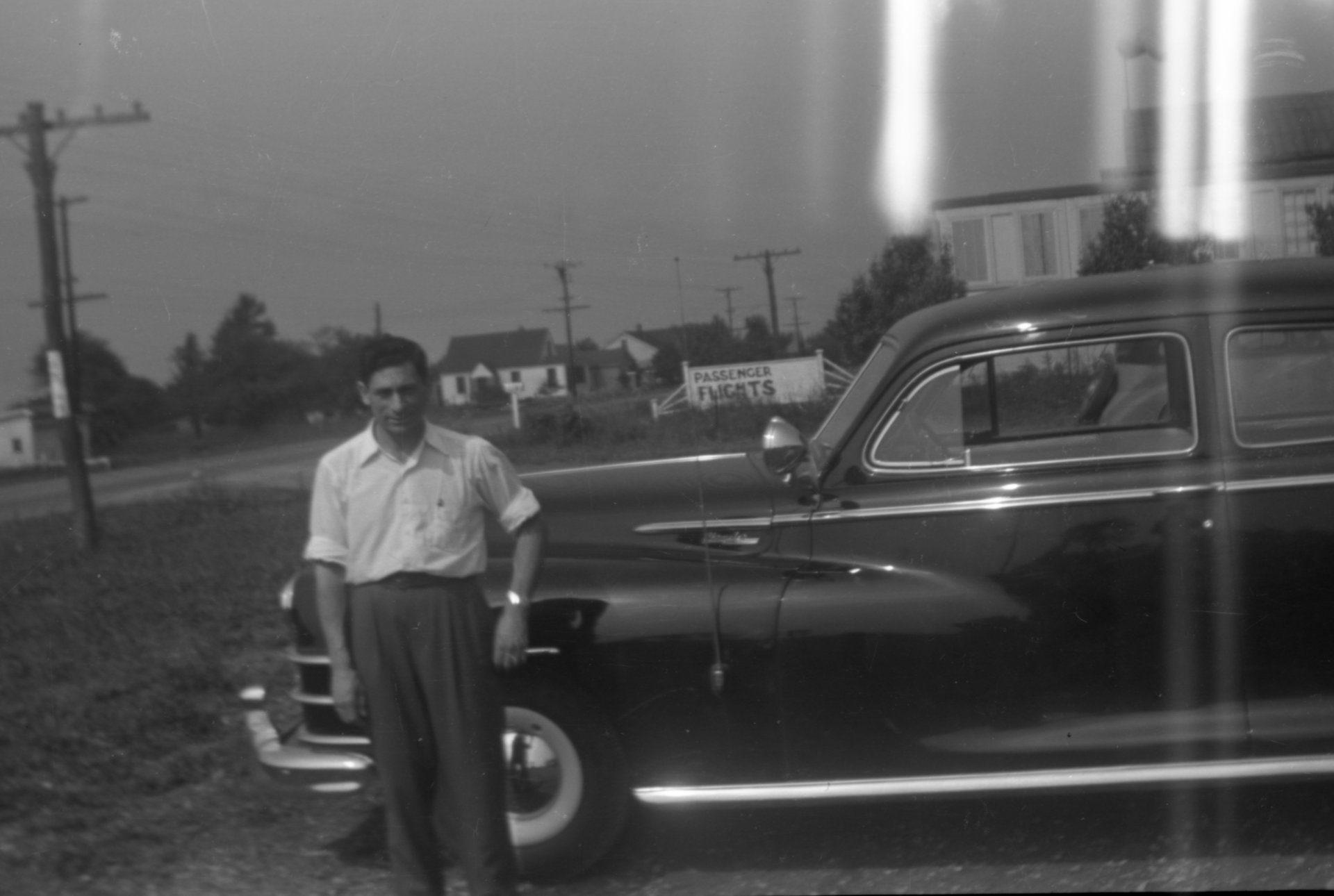Tony Riccio standing in front of a car in the Buffalo Airpark's parking lot.