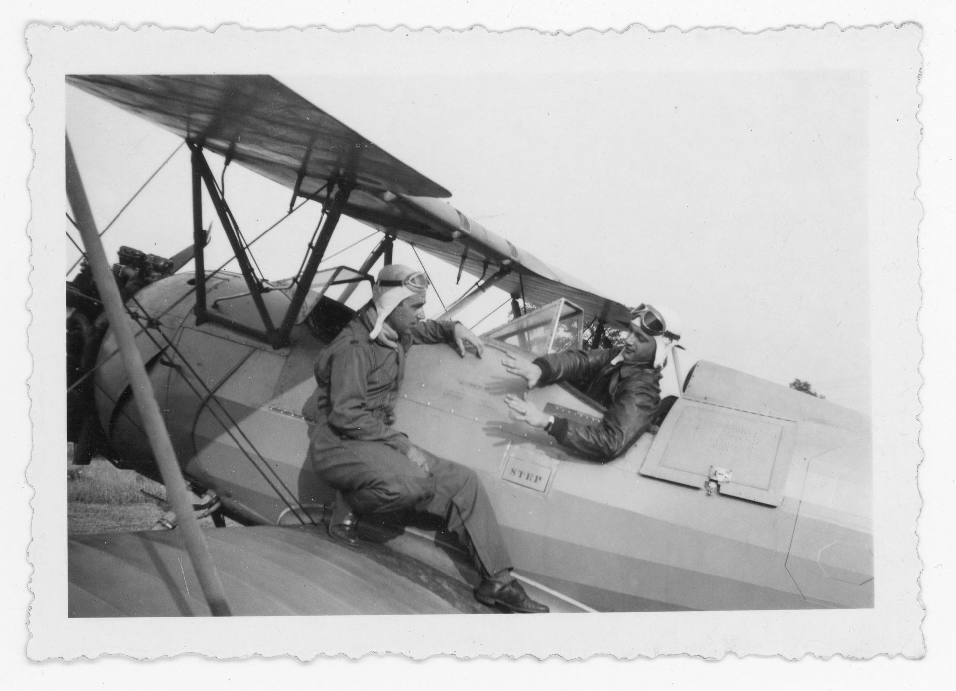 Tony Riccio and his flight instructor talking about a flight lesson while sitting on the wing of an Alexander Eaglerock, A-1.